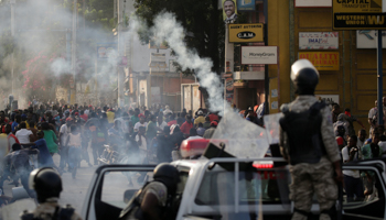 Protesters run away from tear gas fired by the police during clashes at a demonstration called by opposition parties against the government, in the streets of Port-au-Prince, Haiti, November 23, 2018 (Reuters/Andres Martinez Casares)
