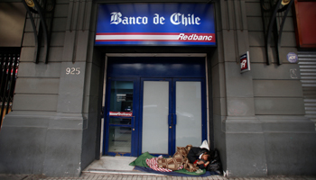 A homeless man sleeping outside a Banco de Chile branch (Reuters/Ivan Alvarado)