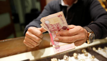 A man counts Libyan dinars at a currency exchange office in Tripoli, April 2016 (Reuters/Ismail Zitouny)