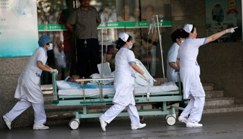 Medical personnel transport a victim of a factory explosion in Jiangsu province (Reuters/Aly Song)