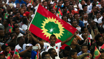 A man holds an Oromo Liberation Front (OLF) flag as people celebrate the returning of Jawar Mohammed, U.S.-based Oromo activist and leader of the Oromo Protests, in Addis Ababa, Ethiopia in August 2018 (Reuters/Tiksa Negeri)