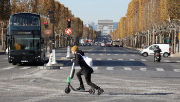 A man passes by the Champs Elysees avenue as he rides a dock-free electric scooter Lime-S by California-based bicycle and scooter sharing service Lime, in Paris, France (Reuters/Charles Platiau)