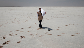 A woman walks on the bed of a dried-up lake in the Maranjab Desert, April 2010 (Reuters/Morteza Nikoubazl)