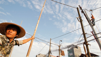 Workers repairing an electric grid in Hanoi (Reuters/Kham)