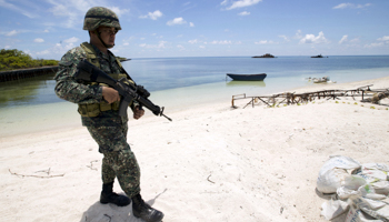 A Filipino soldier patrols at the shore of Pagasa island (Thitu Island) in the Spratly Islands (Reuters/Ritchie B. Tongo)