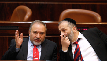 Yisrael Beiteinu leader Avigdor Lieberman (left) speaks with Aryeh Deri, head of Shas, November 2013 (Reuters/Amir Cohen)