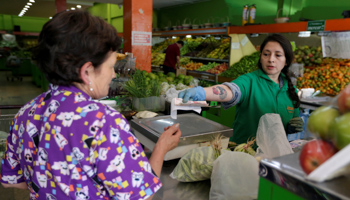 A woman receives her change from a cashier in a supermarket in Bogota, Colombia October 30, 2018 (Reuters/Luisa Gonzalez)
