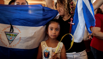 Anti-government protesters hold the national flag during a Palm Sunday mass in Esquipulas, Nicaragua April, 2019. (Reuters/Oswaldo Rivas)