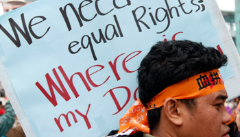 A protester carrying a placard at a migrant workers’ rally in Taipei, 2011 (Reuters/Sheng-fa Lin)