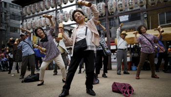 Elderly and middle-age people exercise with wooden dumbbells during a health promotion event to mark Japan's "Respect for the Aged Day" at a temple in Tokyo's Sugamo district, an area popular among the Japanese elderly, September 21, 2015. (Reuters/Issei Kato)
