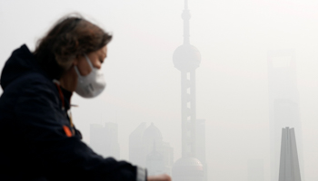 A woman wearing a face mask in front of the financial district of Pudong during a polluted day in Shanghai, China, November 28, 2018 (Reuters/Aly Song)