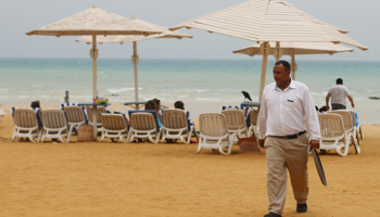 An employee walks beside beach loungers at a tourist resort near Suez, May 2018 (Reuters/Amr Abdallah Dalsh)