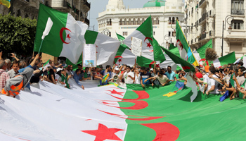 Demonstrators carry national flags during a protest demanding the removal of the ruling elite in Algiers, Algeria, June 21, 2019 (Reuters/Ramzi Boudina)
