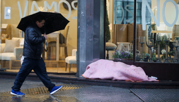 A homeless person sleeping outside a shop going out of business in Buenos Aires (Reuters/Agustin Marcarian)