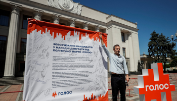 Rock star Svyatoslav Vakarchuk with a banner for his Golos party outside the Ukrainian parliament. (Reuters/Gleb Garanich)