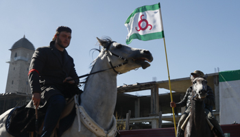 A mounted protester rides past an Ingush flag (Reuters/Maxim Shemetov)