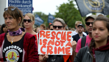 A woman holding a sign that reads "Rescue is not a Crime", attends a demonstration for the rights of migrants crossing the Mediterranean to Europe in Berlin, July 6 (Reuters/Christian Mang)