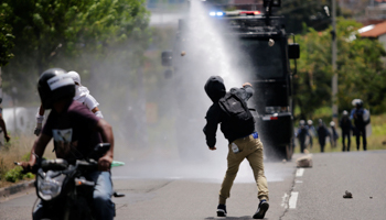 Demonstrators throw stones during an anti-government protest in Tegucigalpa (Reuters/Jorge Cabrera)