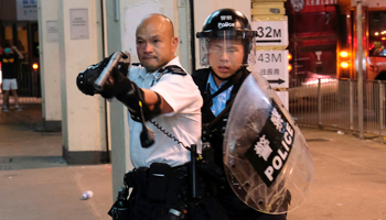 A police officer points a gun towards anti-extradition bill protesters (Reuters/Tyrone Siu)