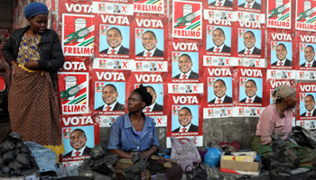 Women selling charcoal in front of ruling FRELIMO election posters in the capital, Maputo (Reuters/Siphiwe Sibeko)