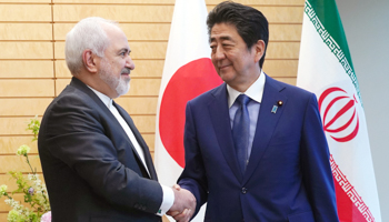 Iranian Foreign Minister Mohammad Javad Zarif, left, and Japanese Prime Minister Shinzo Abe, right, shake hands at Abe's official residence in Tokyo, May 16 (Reuters/Eugene Hoshiko)