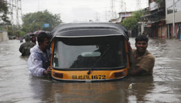 Men pushing an auto rickshaw through a flooded road in Mumbai, India (Reuters/Francis Mascarenhas)