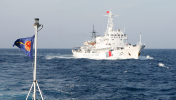 A Vietnam Marine Guard flag and a Chinese Coast Guard ship in the South China Sea, May 2014 (Reuters/Nguyen Ha Minh)