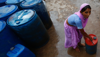 Woman collecting drinking water from a municipal facility in Delhi (Reuters/Anindito Mukherjee)