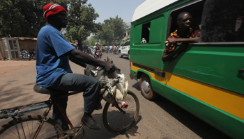 A Malian man with chickens on his bicycle waits to cross a road in Bamako, 2012 (Reuters/Luc Gnago)