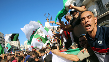 Demonstrators gesture as they carry national flags during a protest against the country's ruling elite and rejecting the Algerian election announcement for December, in Algiers, September 27 (Reuters/Ramzi Boudina)