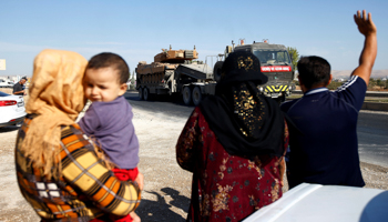 People greet a Turkish military convoy near the Turkish-Syrian border in Sanliurfa province, October 12 (Reuters/Kemal Aslan)