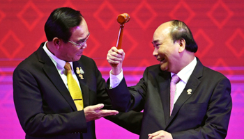 Thailand's Prime Minister Prayut Chan-o-cha (left) handing over ASEAN's chairmanship to Vietnam's Prime Minister Nguyen Xuan Phuc (right) (Reuters/Chalinee Thirasupa)