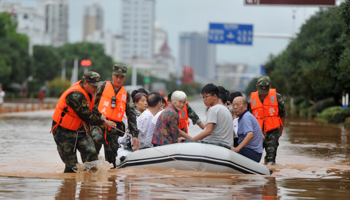 Rescuers evacuate residents with a boat on a flooded street after heavy rainfalls hit Xianning, Hubei province, China, August 13, 2017 (Reuters/Stringer)