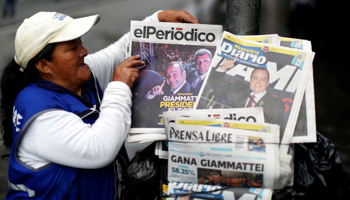 A woman sells newspapers with pictures of Guatemalan President-elect Alejandro Giammattei following his election in August. Guatemala City, August 12, 2019 (Reuters/Jose Cabezas)