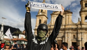 A demonstrator holds a banner that reads "Resistance" during a protest in Bogota, Colombia, December 16 (Reuters/Luisa Gonzalez)