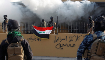 Members of Iraqi security forces are seen in front of US Embassy during a protest to condemn air strikes on PMF bases; Baghdad, January 1, 2020 (Reuters/Khalid al)
