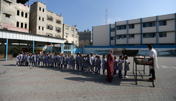 Palestinian schoolgirls in the Gaza Strip queue for food provided by UNRWA, September 2019 (Reuters/Ibraheem Abu Mustafa)