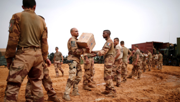 French soldiers carry boxes of bottled water in the Gourma region during Operation Barkhane in Ndaki, Mali, July 2019 (Reuters/Benoit Tessier)