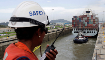 A worker talks on a walkie talkie as a cargo ship navigates through locks at the Panama Canal (Reuters/Carlos Jasso)