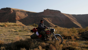 A man rides on a motorcycle near the uranium ore dump near the town of Mailuu-Suu, Kyrgyzstan, October 23, 2019 (Reuters/Pavel Mikheyev)