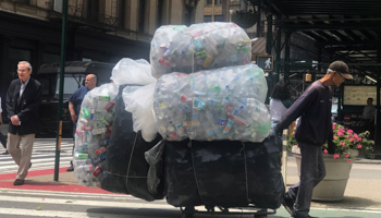 A man pulls a cart full of recyclable containers though the street in the Manhattan borough of New York City, New York, United States, June 12, 2019 (Reuters/Carlo Allegri)