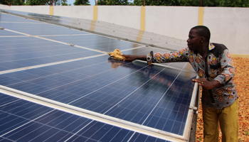 A man cleans solar panels used to provide electricity to Sikpe Afidegnon village, Togo, May 16, 2019 (Reuters/Noel Kokou Tadegnon)