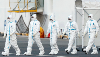 Workers wearing protective suits walk away from the quarantined cruise ship Diamond Princess in Yokohama (Reuters/Kim Kyung)