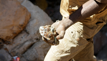 An artisanal miner carries raw ore at a former industrial copper-cobalt mine, Kolwezi, June 11, 2016. (Reuters/Kenny Katombe)