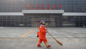A cleaner walks past the Sihui Long Distance Bus Station in Beijing  (Reuters/Thomas Peter)