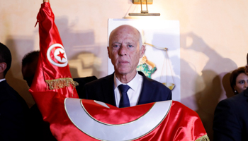 President Kais Saied holds the Tunisian flag after exit polls indicating his election victory, October 2019 (Reuters/Zoubeir Souissi)