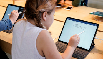 A girl uses an iPad at the grand opening of the new Apple Carnegie Library store in Washington, U.S., May 11, 2019 (Reuters/Joshua Roberts)