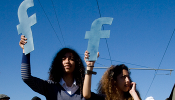 Moroccan protesters hold Facebook logos in recognition of the platform’s role in the Arab uprisings, March 2011 (Reuters/Adam Tanner)