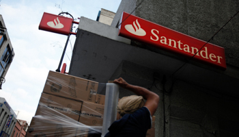 A worker wraps merchandise with plastic film in front of a branch of Santander in downtown Mexico City (Reuters/Tomas Bravo)