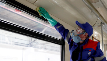 A masked worker cleans an underground train in Moscow (Reuters/Evgenia Novozhenina)